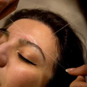 Mujer haciendo depilación con hilo